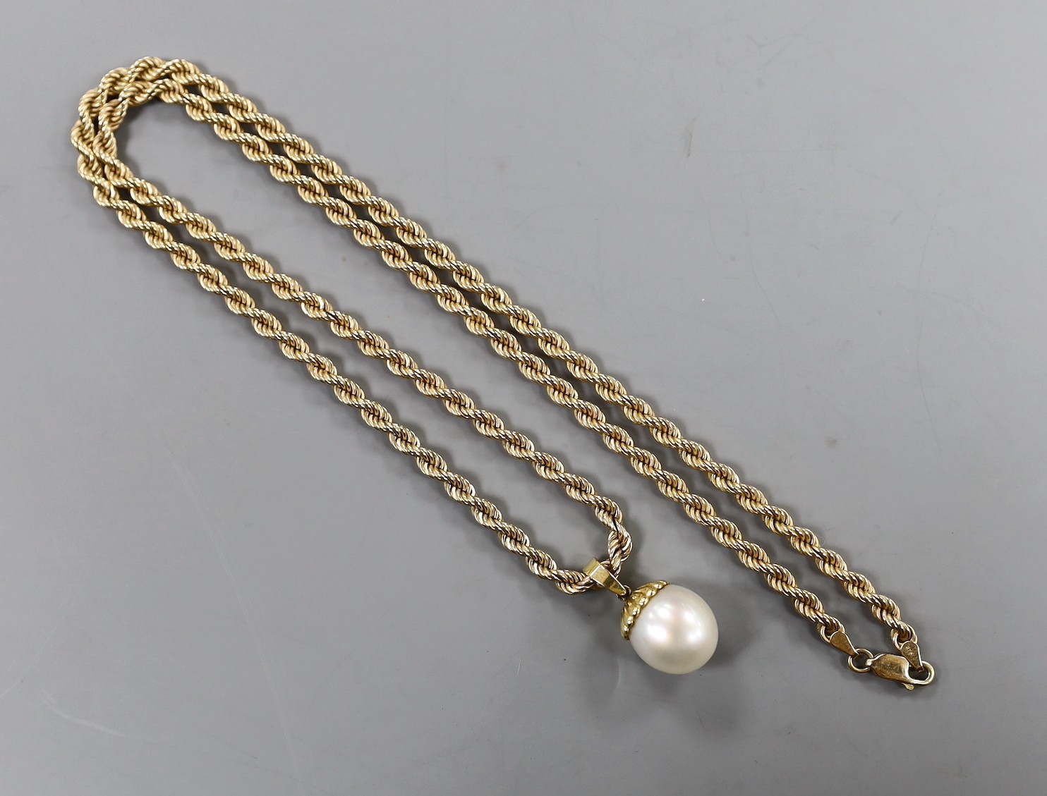 A modern 750 mounted cultured pearl pendant, overall 25mm, on a 375 ropetwist chain, 60cm, gross weight 42.2 grams.